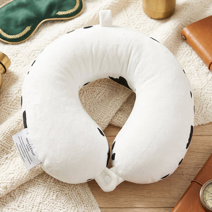 Plush cow print travel cushion for napping on journeys